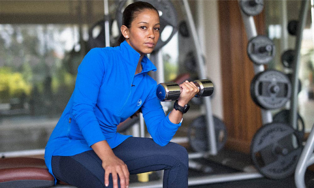 An international customer in Oman exercising in a blue Spark Half-Zip, a modest sportswear sweatshirt by Veil Garments.