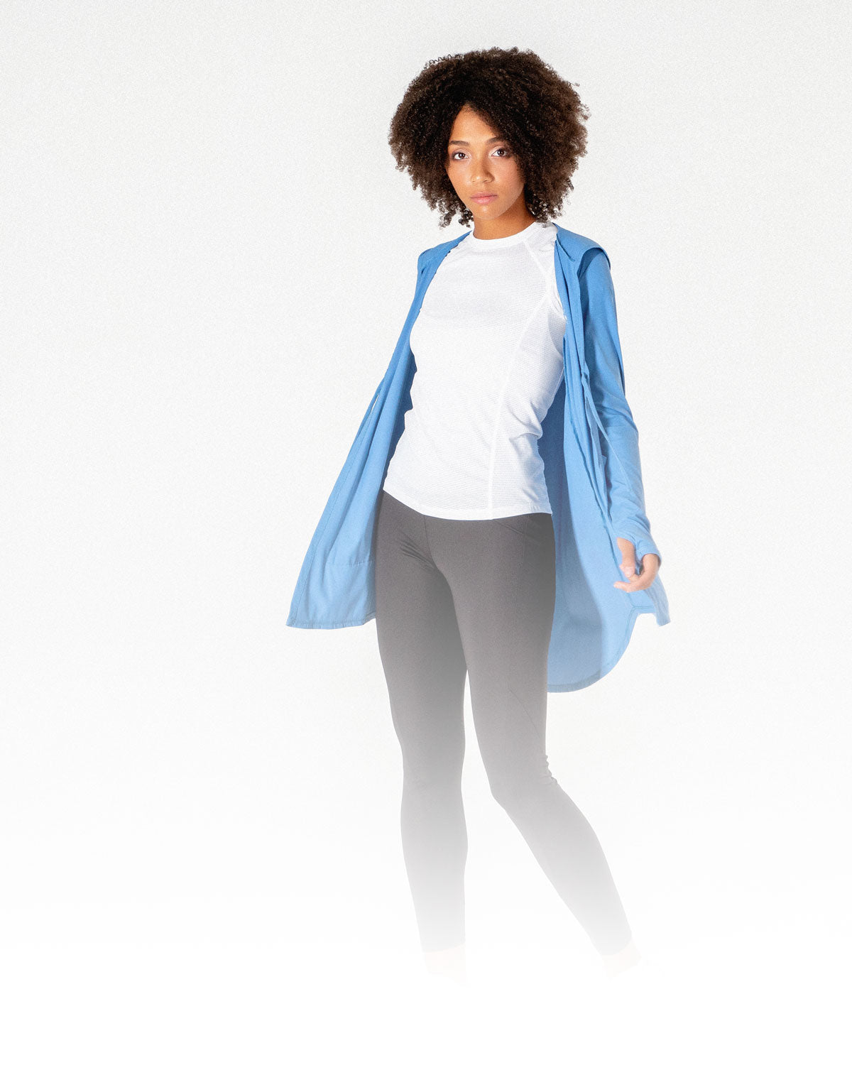 A female posing in a light blue Move It Cardigan, a modest sportswear cardigan from Veil Garments.