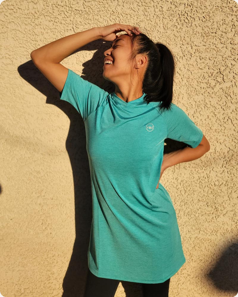 A customer smiling and posing in her Connect T-Shirt Dress, a modest activewear t-shirt from Veil Garments.