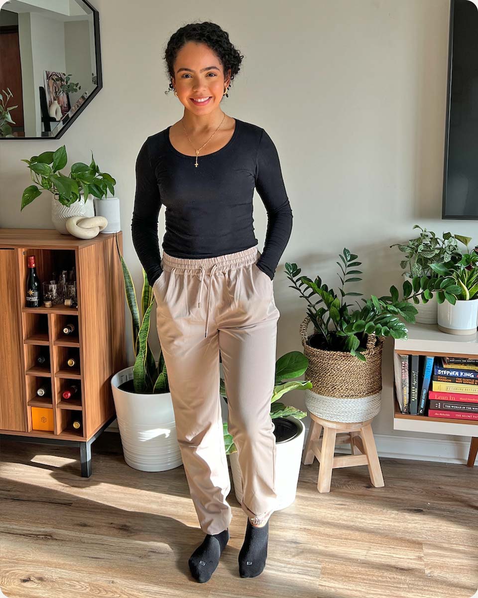 Customer smiling and posting in the beige Glider Drawstring Jogger, a modest activewear jogger from Veil Garments.