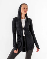 Front view of the black Move It Cardigan with the hood up and the front tie fastened over a white tee.

#color_black