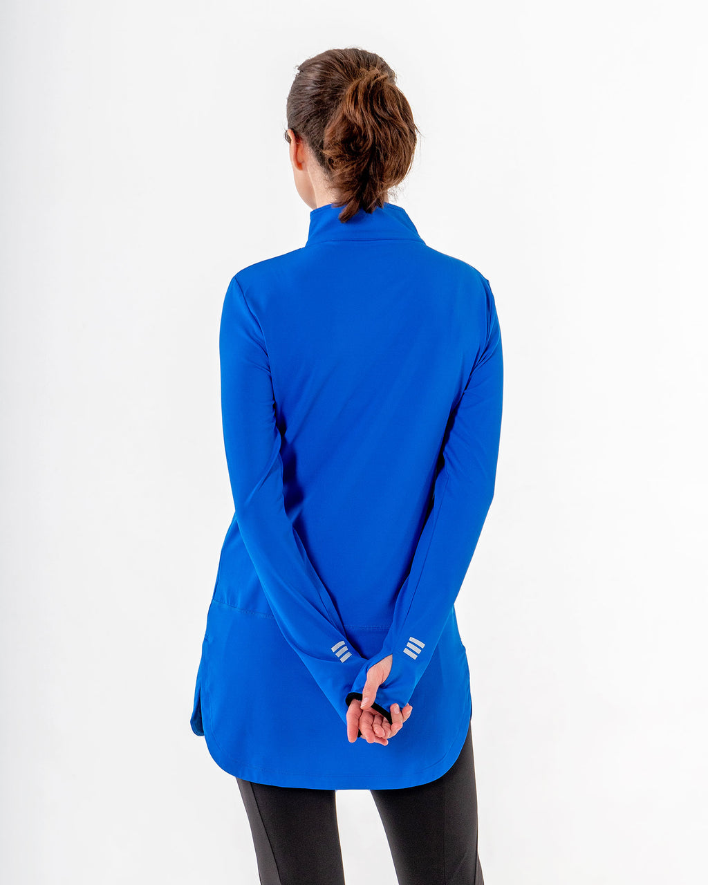 Back of the Spark Half-Zip in royal blue, hands clasped low, reflective marks at the cuffs.

#color_royal-blue