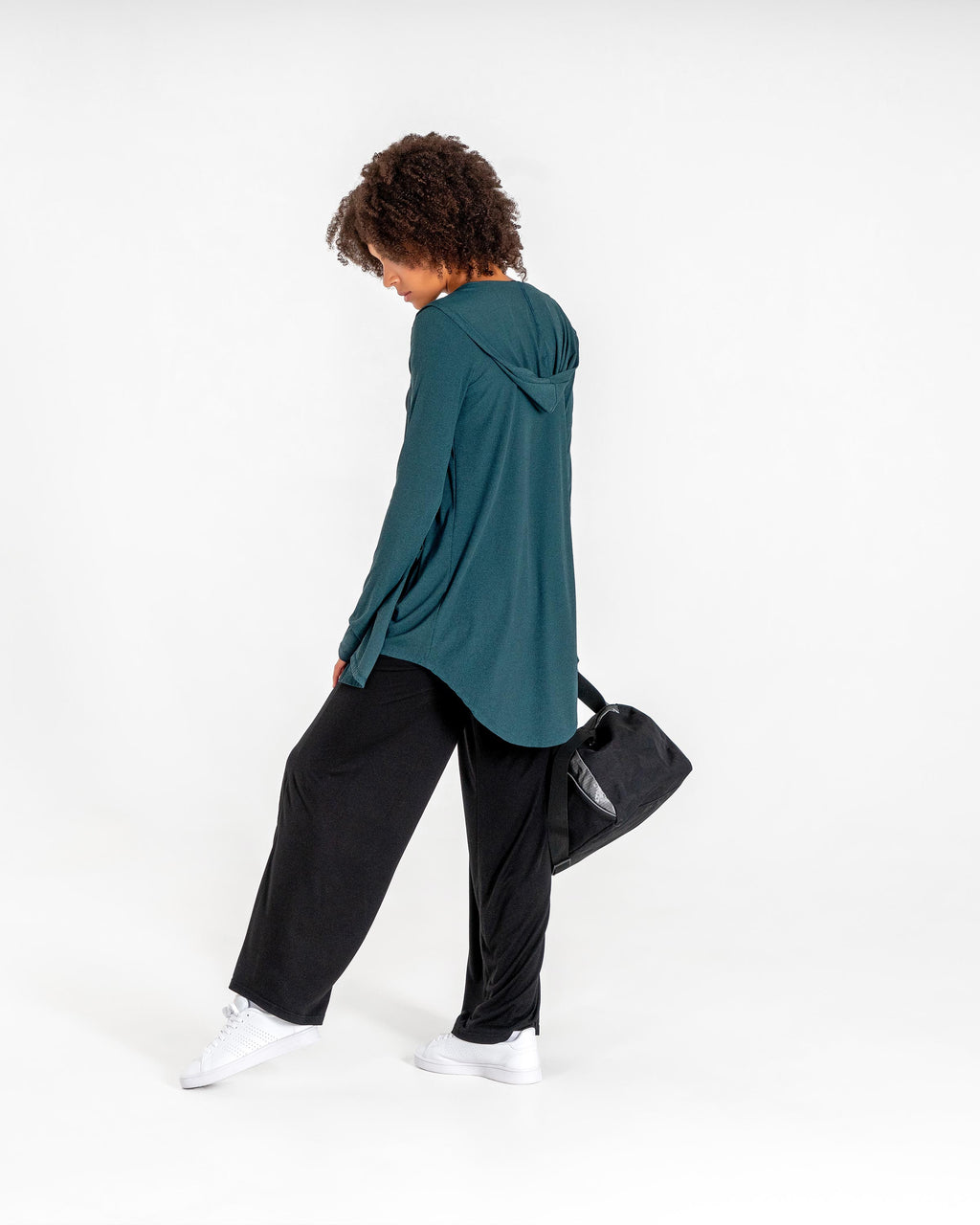 Emerald green Move It Cardigan from behind, worn with black wide-leg pants and a gym duffel.

#color_emerald-green