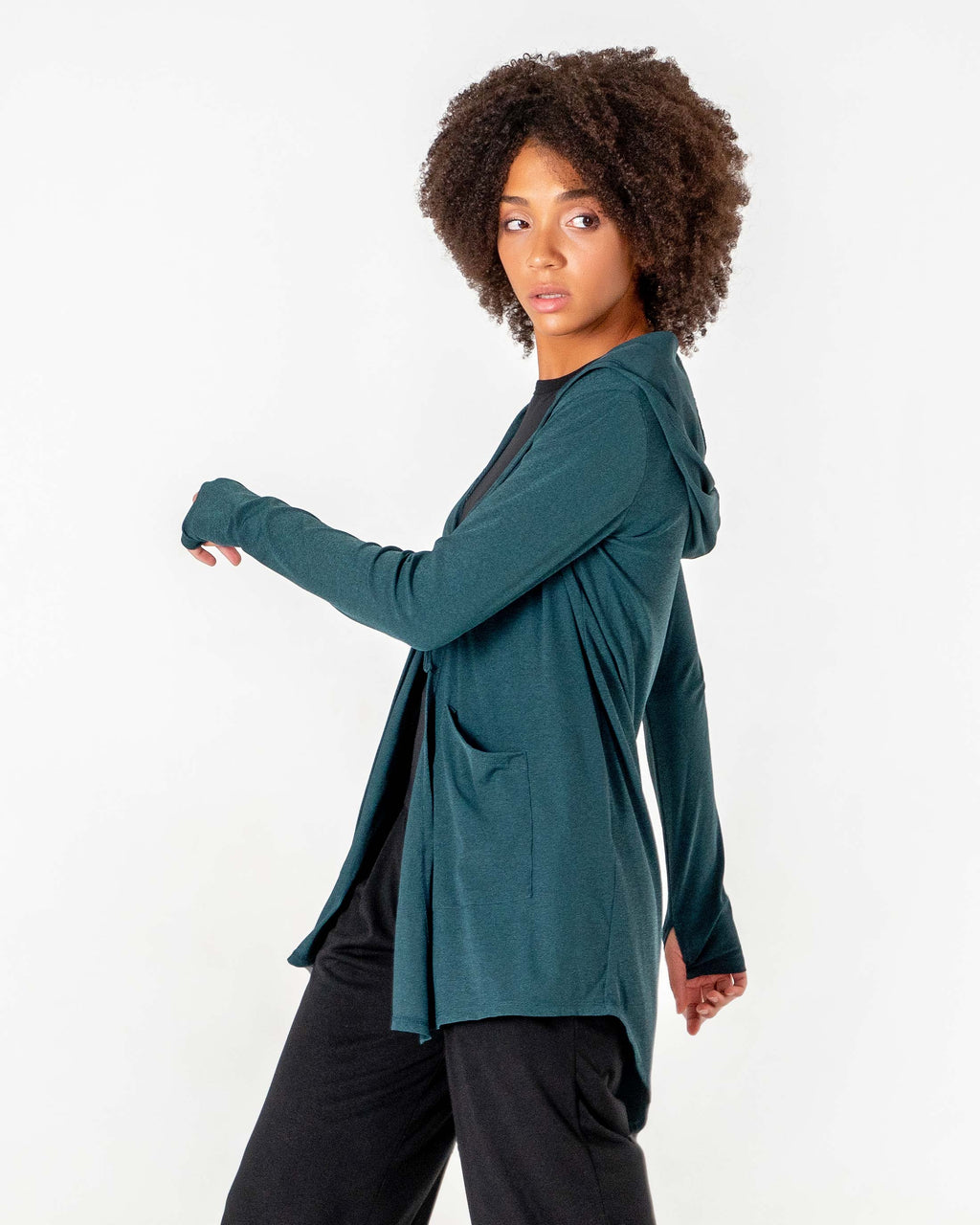 Side view of the emerald green Move It Cardigan with one arm forward and the thumbhole cuff visible.

#color_emerald-green